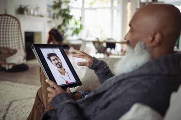 Senior man video chatting with doctor on digital tablet screen - CAIF32645