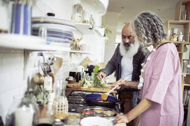 Senior couple cooking at kitchen stove - CAIF32652