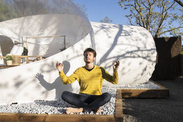 Mann mit geschlossenen Augen beim Yoga an einem sonnigen Tag - JCCMF06338