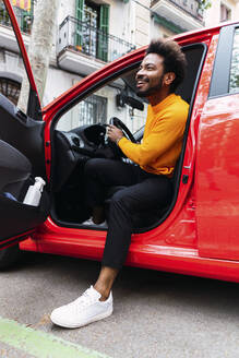 Glücklicher Afro-Mann beim Aussteigen aus dem Auto - PNAF03866