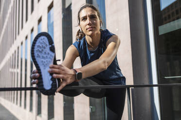 Young woman exercising in front of building - JSRF02008