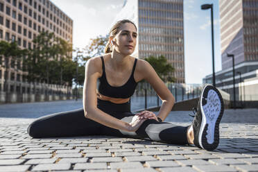 Flexible junge Frau beim Sport auf dem Fußweg - JSRF02021