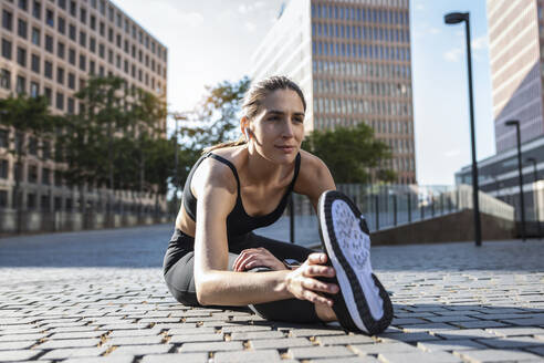Flexible Frau beim Sport auf dem Fußweg in der Stadt - JSRF02022