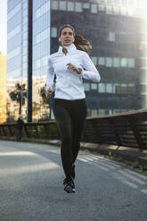 Young woman jogging on footbridge - JSRF02034