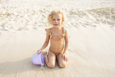 Mädchen mit Sandkübel spielt am Strand - SVKF00178