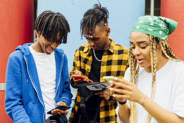 Happy young men and woman using smart phones - MEUF05714