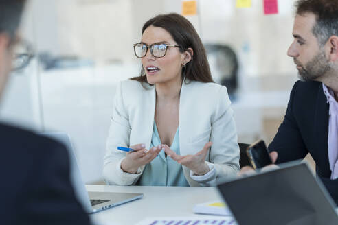 Businesswoman explaining colleagues in meeting at office - JSRF02096