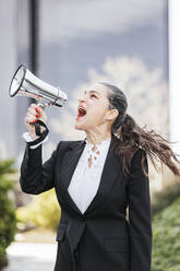Mature businesswoman screaming through megaphone - IFRF01700