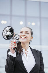 Smiling businesswoman holding megaphone - IFRF01702