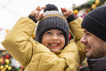 Glücklicher Junge mit Vater auf dem Weihnachtsmarkt - SSGF00955