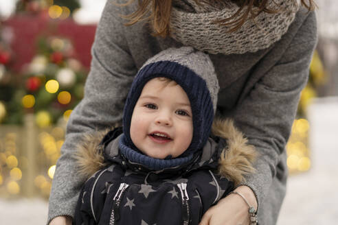 Niedlicher Junge mit Mutter auf dem Weihnachtsmarkt - SSGF00969