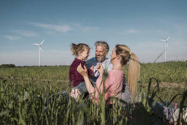 Happy girl with parents in field on sunny day - MOEF04103