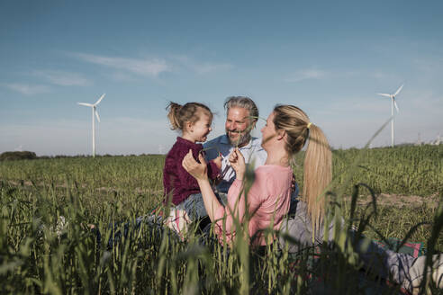 Glückliches Mädchen mit Eltern auf dem Bauernhof an einem sonnigen Tag - MOEF04103