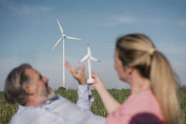 Frau mit Windmühlenmodell und Freund auf dem Bauernhof - MOEF04110