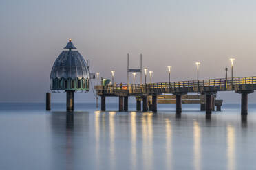 Germany, Mecklenburg-Western Pomerania, Zingst, Long exposure of Zingst Pier at dusk with Tauchgondel in background - KEBF02283