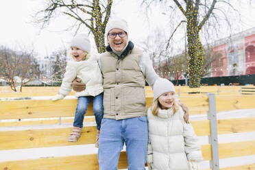 Happy man with daughters enjoying at Christmas market - SIF00129