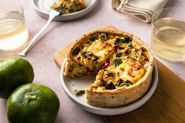 Studioaufnahme einer frisch gebackenen Zucchini-Quiche mit roter Paprika und Zwiebeln - FLMF00814