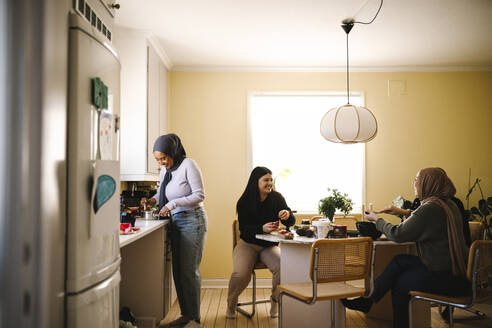 Glückliche junge Frauen bei der Zubereitung von Speisen in der Küche zu Hause - MASF29940