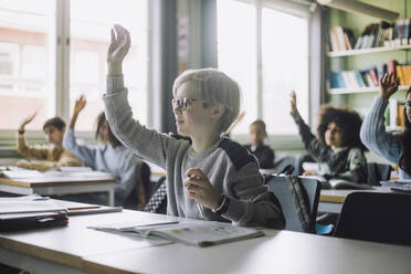 Boy with hand raised attending lecture in classroom - MASF30012