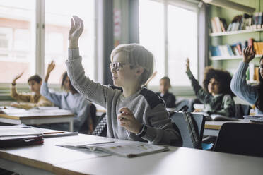 Junge mit erhobener Hand bei einer Vorlesung im Klassenzimmer - MASF30012