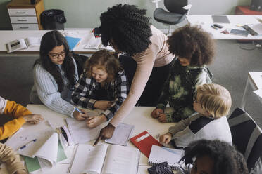 Teacher pointing at book while teaching in classroom - MASF30065