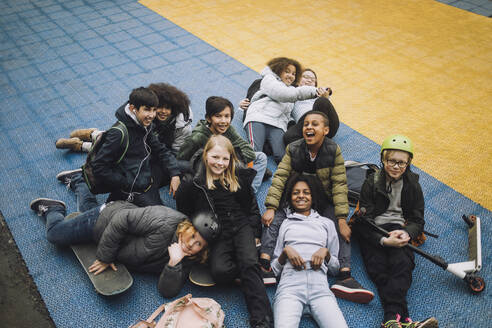 Hoher Blickwinkel auf diverse Schüler, die sich auf dem Sportplatz entspannen - MASF30132