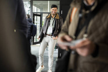 Glücklicher Geschäftsmann vor einem Konferenzzentrum - MASF30137