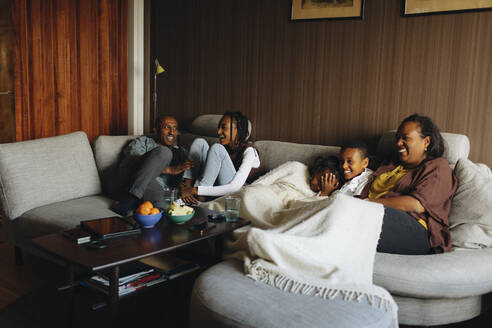 Glückliche Familie sitzt zusammen auf dem Sofa im Wohnzimmer zu Hause - MASF30275