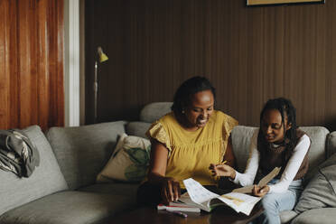 Daughter discussing with mother while studying at home - MASF30311