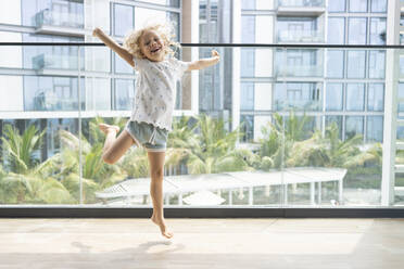Fröhliches Mädchen springt auf Balkon - SVKF00207