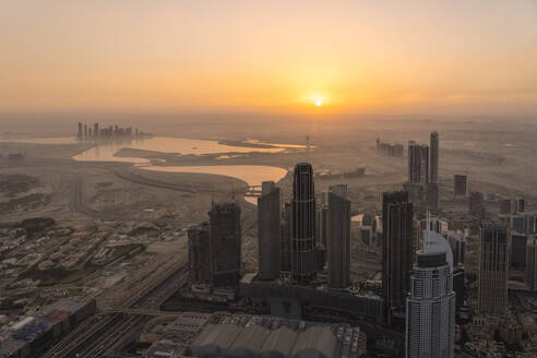 Vereinigte Arabische Emirate, Dubai, Stadtzentrum bei nebligem Sonnenaufgang mit Business Bay und Dubai Creek im Hintergrund - TAMF03369