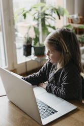Mädchen mit Laptop beim Lernen zu Hause - LHPF01456