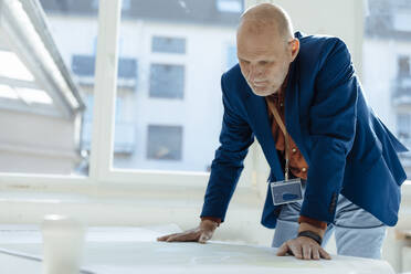 Businessman analyzing design at desk in office - JOSEF09741