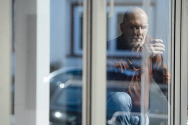 Geschäftsmann mit Trinkglas im Büro durch ein Fenster gesehen - JOSEF09800