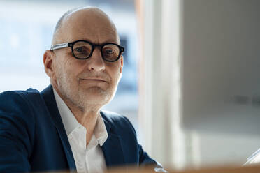 Senior businessman wearing eyeglasses at office - JOSEF09857