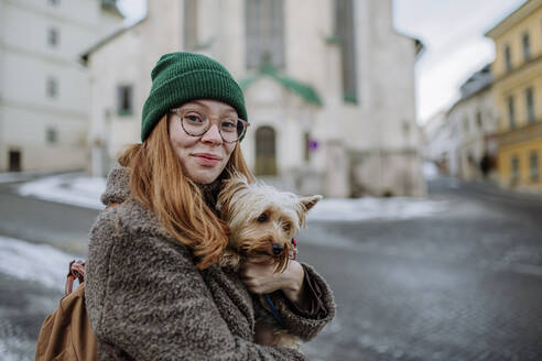 Smiling woman with Yorkshire Terrier in city - HAPF03188