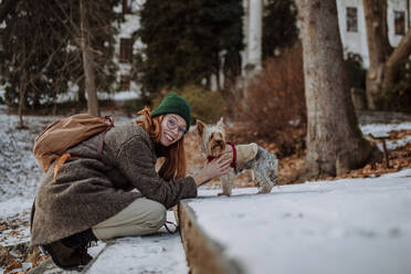 Happy woman with pet dog leaning on steps - HAPF03200