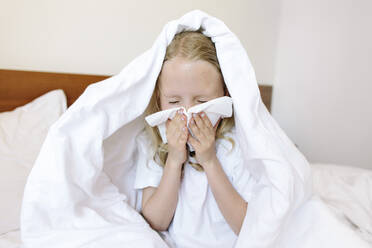 Mädchen schnäuzt Nase mit Taschentuch zu Hause - SIF00156