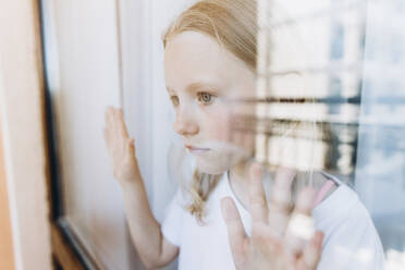 Thoughtful girl looking through glass window - SIF00162