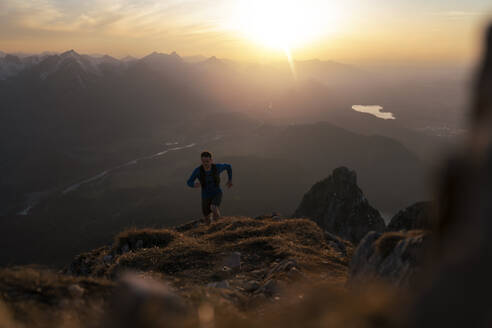 Mann beim Wandern auf dem Berg Sauling bei Sonnenuntergang - MALF00401