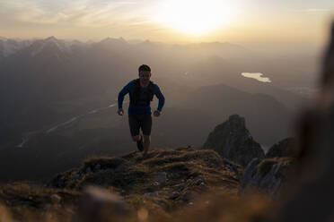 Mann läuft bei Sonnenuntergang auf den Berg Sauling - MALF00403