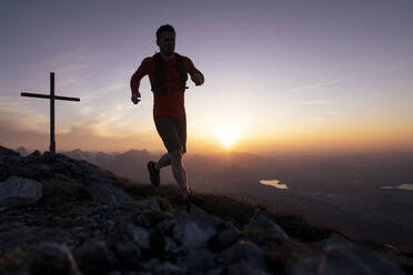 Silhouette Mann läuft auf dem Gipfel des Sauling bei Sonnenuntergang - MALF00415