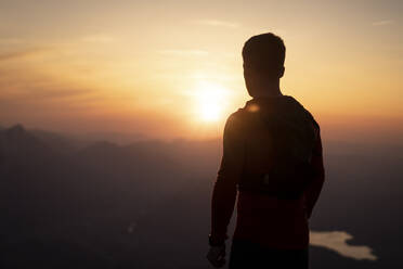 Silhouette man looking at sunset from Sauling mountain - MALF00419