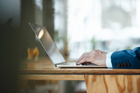 Hände eines Geschäftsmannes, der in einem Café am Laptop arbeitet - JOSEF09941