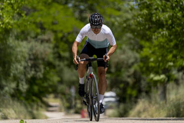 Sportler fährt Fahrrad an einem sonnigen Tag - OCMF02396