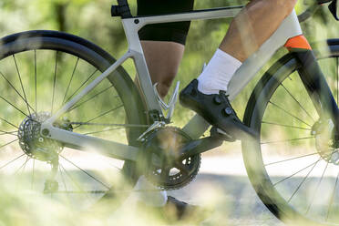 Cyclist standing with bicycle on road - OCMF02402