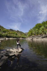 Woman standing on rock at river Sil - DAMF00936