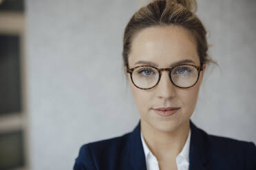 Confident businesswoman wearing eyeglasses in office - JOSEF10001