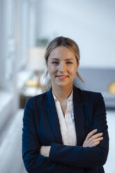 Smiling beautiful businesswoman with arms crossed in office - JOSEF10014