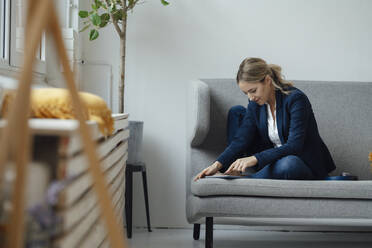 Geschäftsfrau mit Tablet-PC auf dem Sofa im Büro sitzend - JOSEF10021